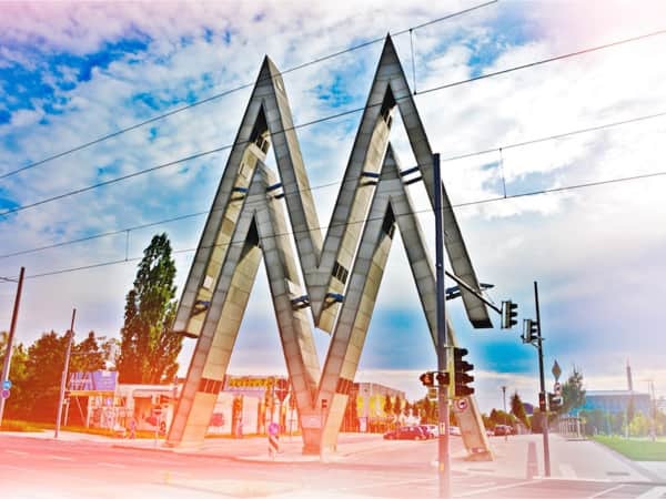 Zweimal der große Buchstabe "M" übereinander. Das Logo der Messe Leipzig. Dargestellt, weil eine Segway-Tour entlang führt.